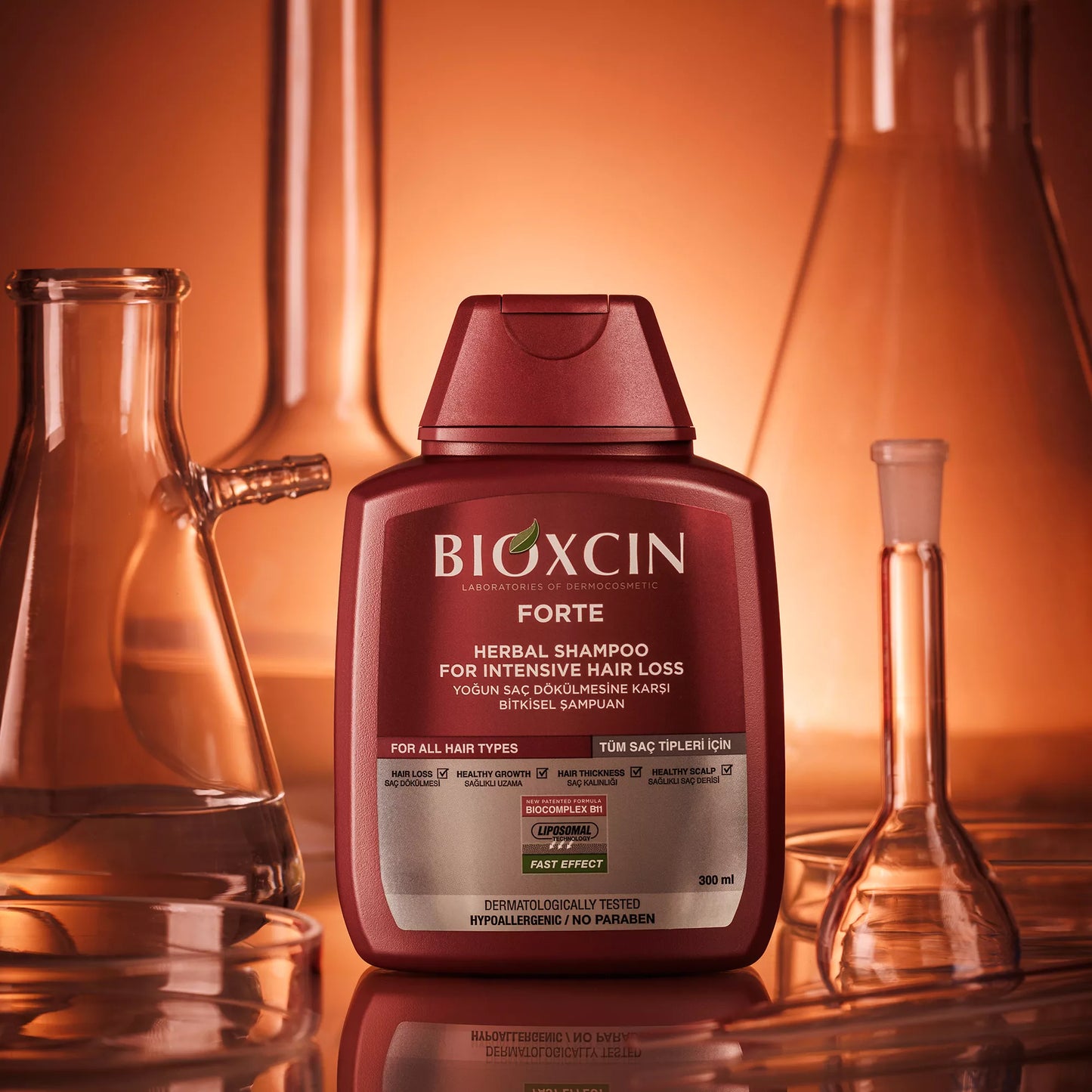 Bioxcin Forte herbal shampoo bottle with laboratory beakers in the background