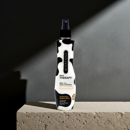 Bottle of Morfose Milk Therapy conditioner on a concrete surface with a dark background