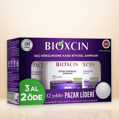 BIOXCIN Black Garlic Triple Pack Shampoo hair care box set featuring a purple retail package with product bottles visible through a window, plus a green promotional badge reading '3 AL 2 ÖDE'.