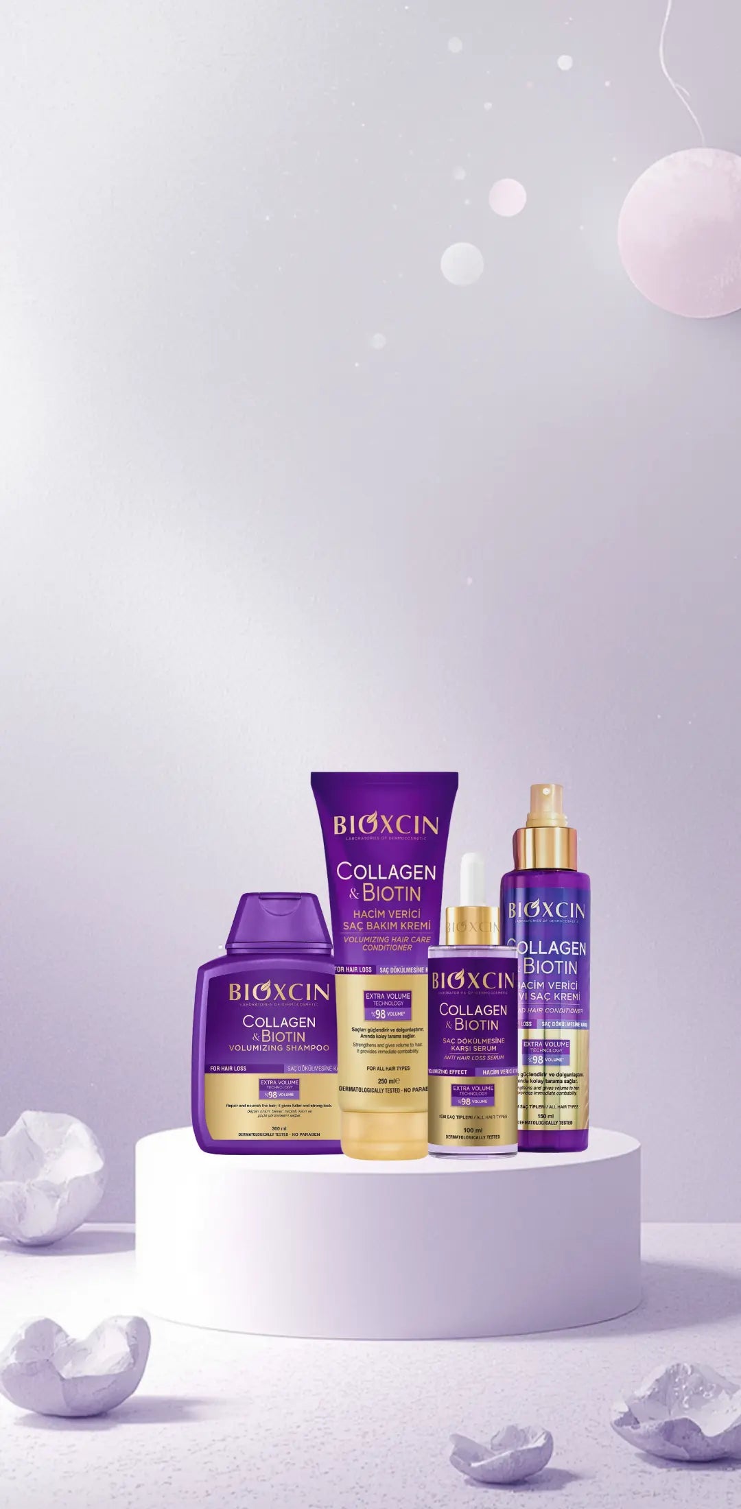 Bioxcin Collagen & Biotin skincare products on a white pedestal with a light purple background.