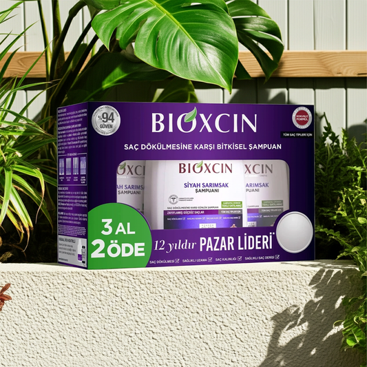 Bioxcin Black Garlic shampoo packaging with green leaves in the background