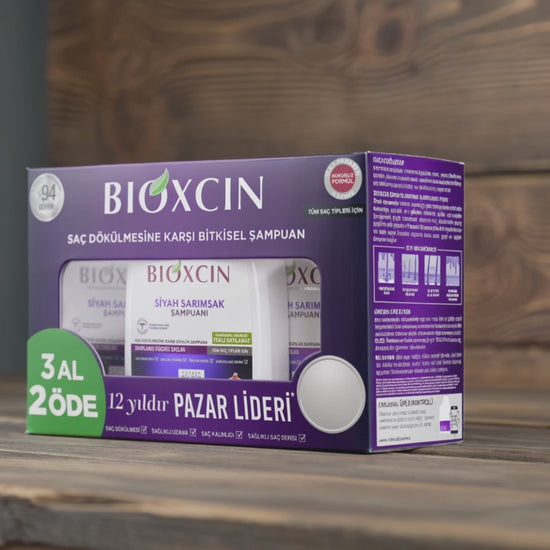 BIOXCIN Black Garlic shampoo packaging box on a wooden surface with a wooden background, featuring purple and white packaging with a green promotional badge.