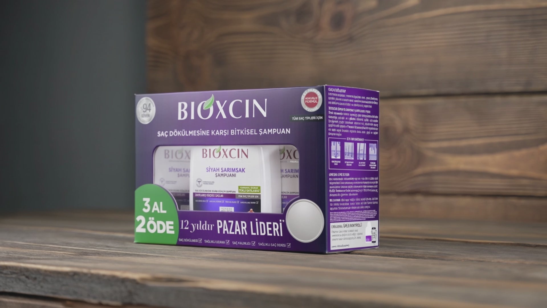 BIOXCIN Black Garlic shampoo packaging box on a wooden surface with a wooden background, featuring purple and white packaging with a green promotional badge.